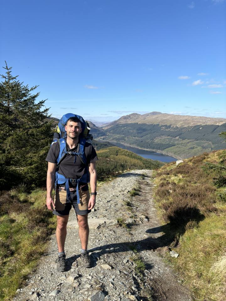 Thomas backpacking on a ridge above a Scottish loch